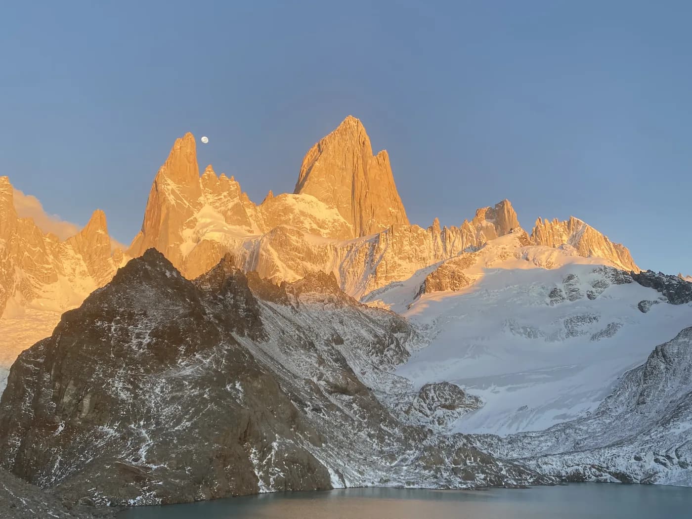 Original photo: Fitz Roy in Patagonia at sunrise, the spires golden, the moon still above and a glacial lake in the foreground