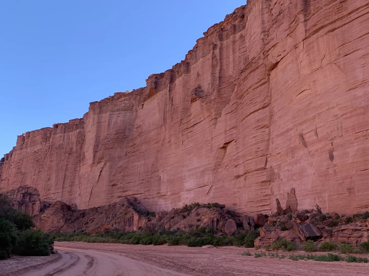 Original photo: a red sandstone cliff above a sand track
